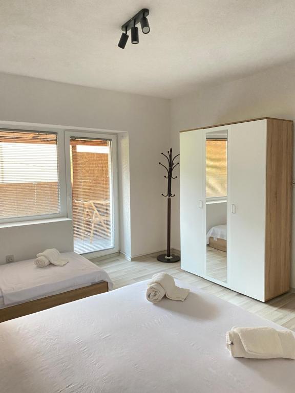 a white bedroom with two beds and a mirror at Lake City Apartment in Struga