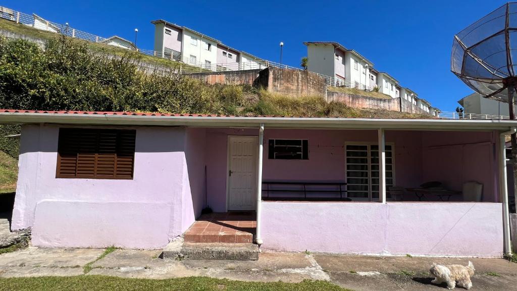 a pink house with a hill on top of it at Lar doce lar da Neuza in Campos do Jordão