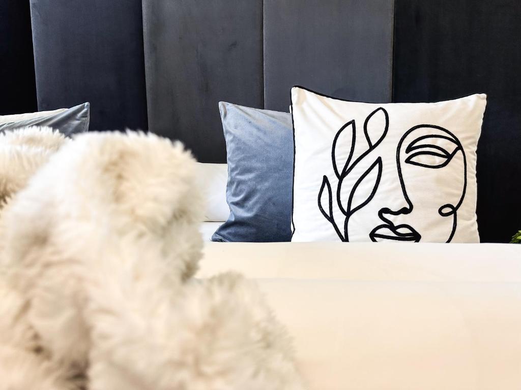 a white bed with a pillow with a face on it at Boutique Hotel Pinzgauerhof in Kaprun