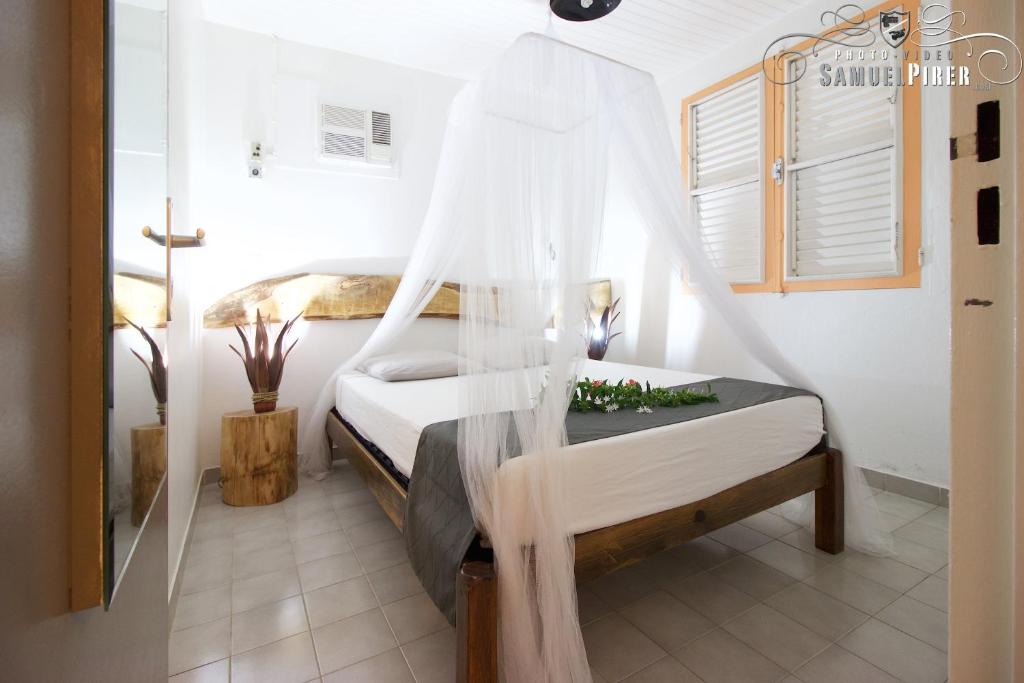 1 dormitorio con 1 cama con mosquitera en Orcéa & Spa Séjours Ecofriendly, en Sainte-Anne