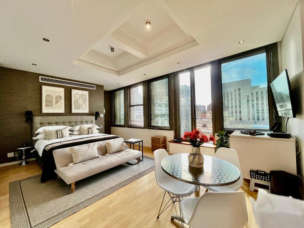 Un dormitorio con una cama y una mesa y sillas. en #608 Cartwright - Urban Hideaway, en Ciudad del Cabo