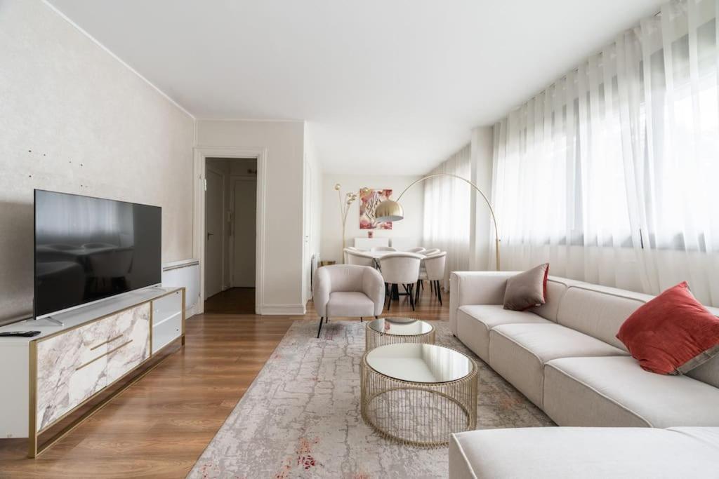 un salon avec un canapé et une télévision dans l'établissement A Refined 2-bedroom close Avenue Foch, à Paris