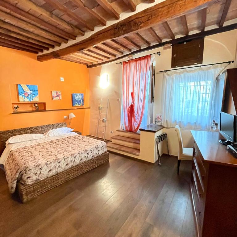 a bedroom with a bed and a desk and a television at Dimora Del Corso Di Montepulciano in Montepulciano