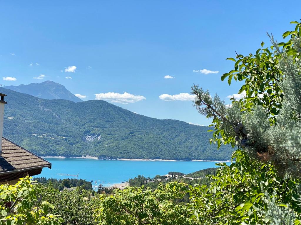 une vue d'un lac avec des montagnes en arrière-plan dans l'établissement Domaine de la baie Saint-Michel le Piolit, à Prunières