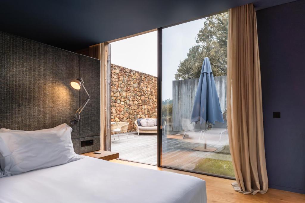 um quarto com uma cama e uma janela grande em Monverde - Wine Experience Hotel - by Unlock Hotels em Amarante
