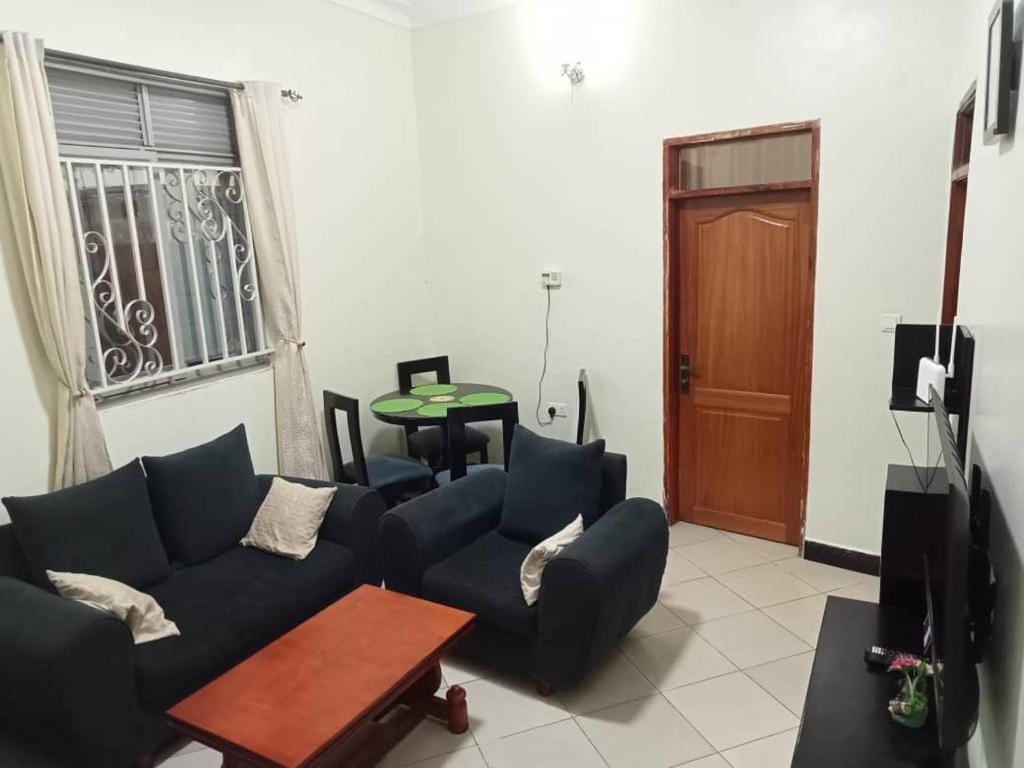 una sala de estar con un sofá y una mesa en Emmilicia holiday homes, en Kampala