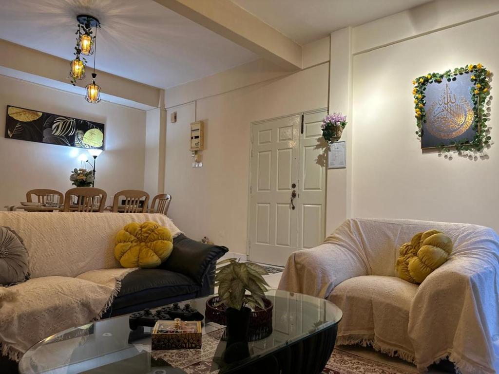 een woonkamer met twee banken en een tafel bij Casuarina Lot-1103 Malacca in Melaka