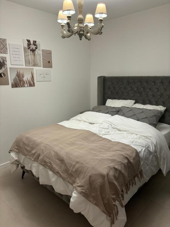 - une chambre avec un grand lit et une tête de lit grise dans l'établissement Gruissan HUBLOTS DU PORT, à Gruissan