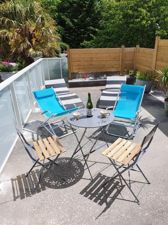 d'une table, de deux chaises et d'une bouteille de vin. dans l'établissement Jardin clos et calme, vélos à disposition, plages à 2 kms, à Tréffiagat