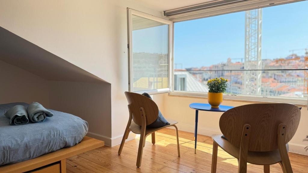 ein Schlafzimmer mit einem Bett, einem Tisch und Stühlen in der Unterkunft Blue Rossio Studio in Lissabon