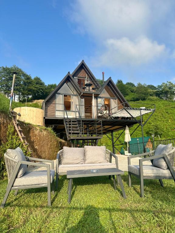 a house with a couch and two chairs in front of it at SilenT Hill Cottage in Gant'iadi
