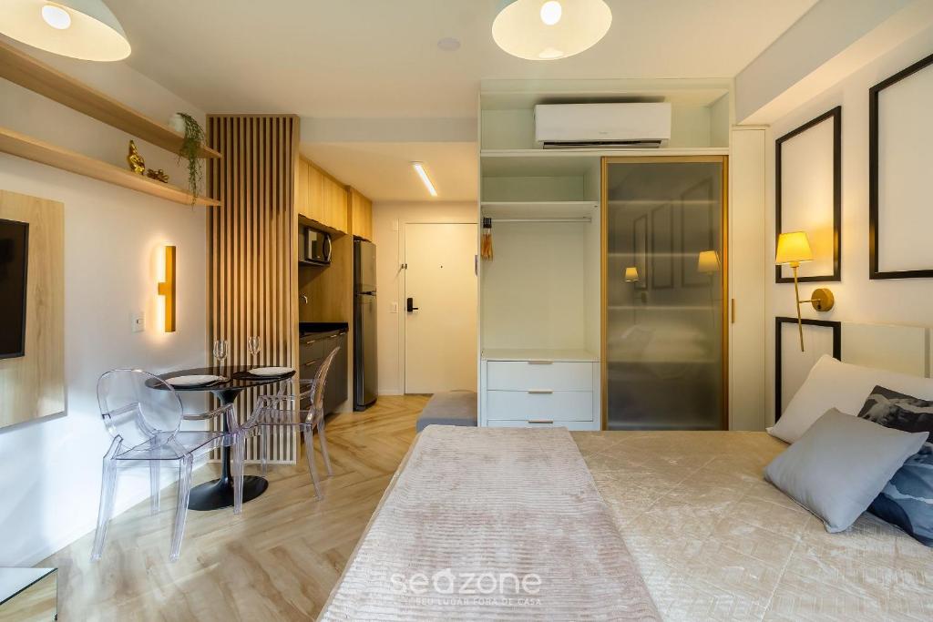 a room with a bed and a table and a kitchen at Studio de luxo e Sofisticado no Moinhos LBO203 in Auxiliadora