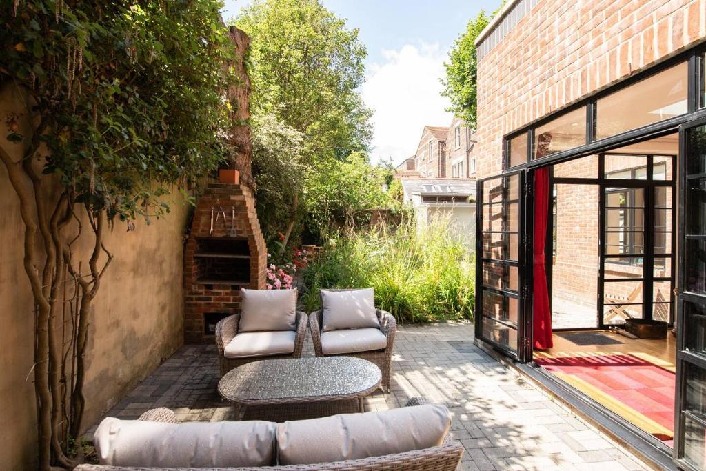 a courtyard with couches and a table in a building at Wildflower Garden - Spacious Garden Apartment in Portsmouth