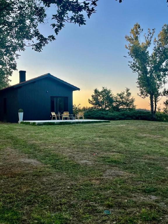une grange avec deux chaises et une table dans un champ dans l'établissement Casa Sirra, à Saint-Germain-des-Prés