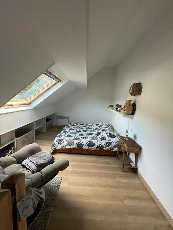 a attic bedroom with a bed and a couch at Gipsy Chic Duplex on the beach in Carolles