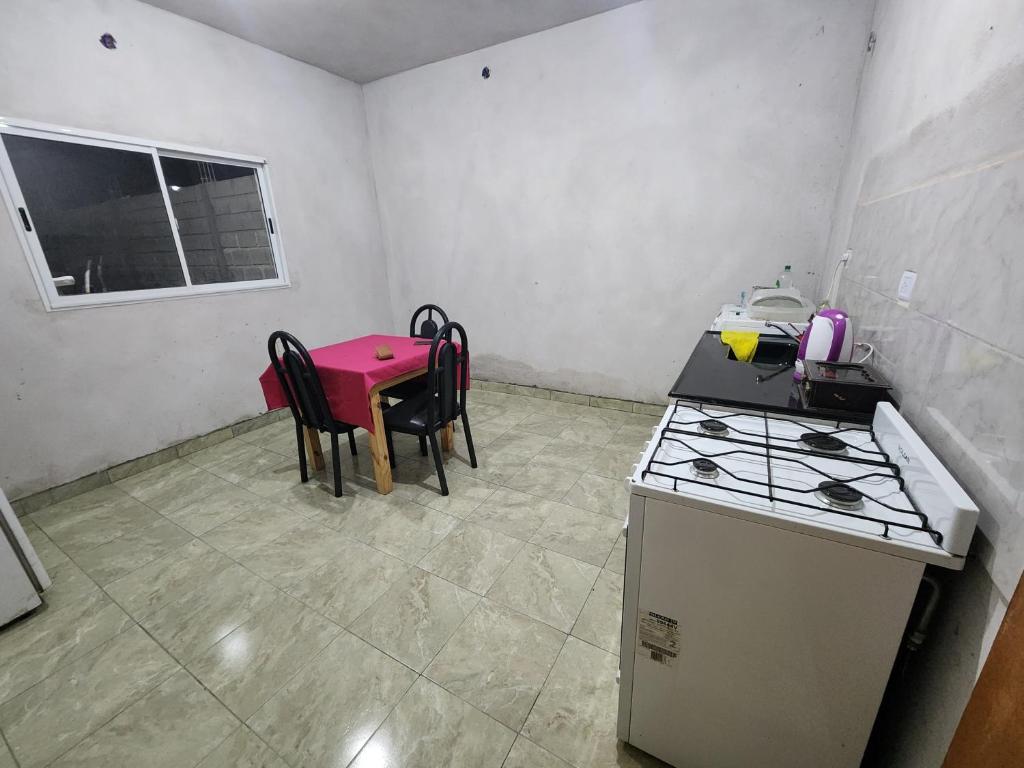 une cuisine avec une cuisinière et une table avec des chaises dans l'établissement Departamentos Catamarca, à San Fernando del Valle de Catamarca
