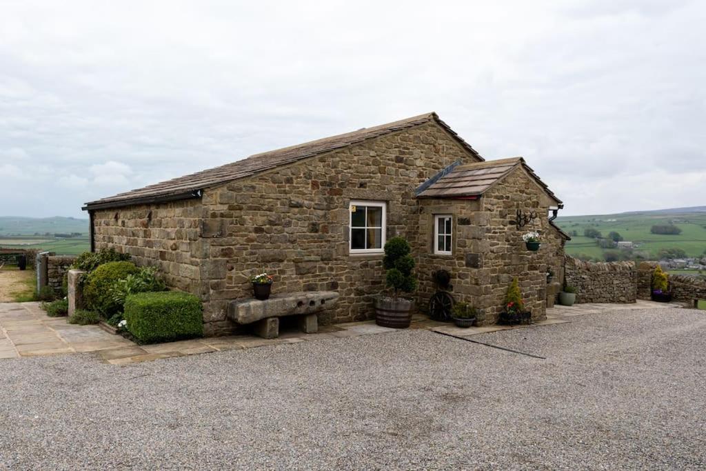 a stone building with a bench in front of it at The Croft Holiday Cottage - AA Accredited, Country Cottage in Colne