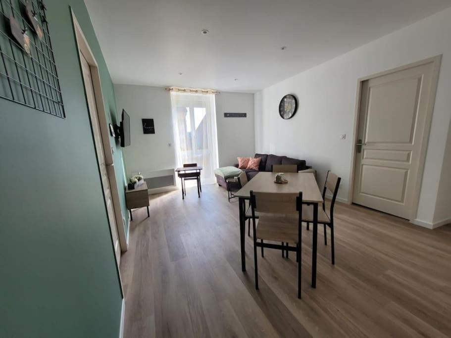 Una sala de estar con una mesa y sillas y un sofá. en Logement centre le bugue, en Le Bugue