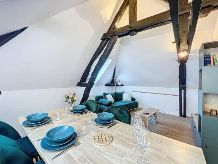 une salle à manger avec une table et un canapé dans l'établissement le vert, à Troyes