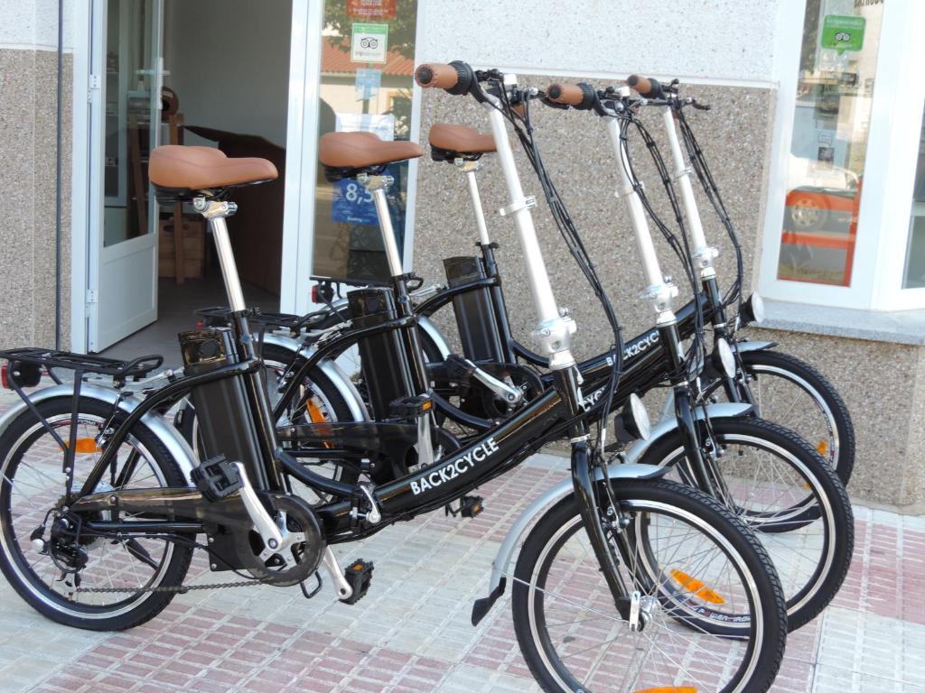 dos bicicletas estacionadas una al lado de la otra frente a una tienda en Apartamento Barbancho, en Casar de Cáceres