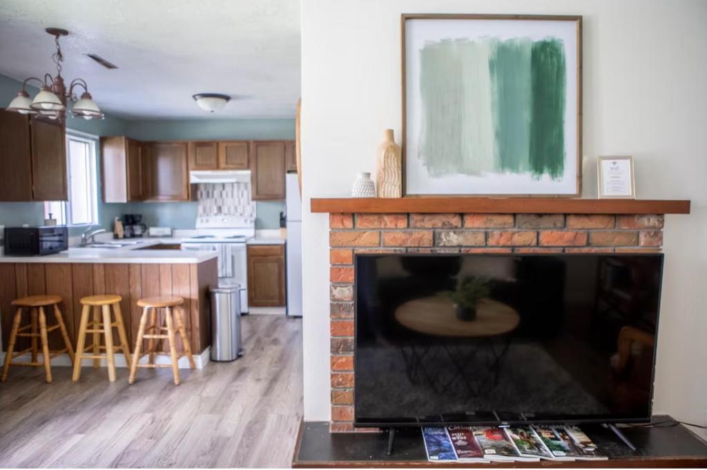 een keuken en een woonkamer met een open haard bij Cozy Twin Pines Apartment-Great Falls in Great Falls