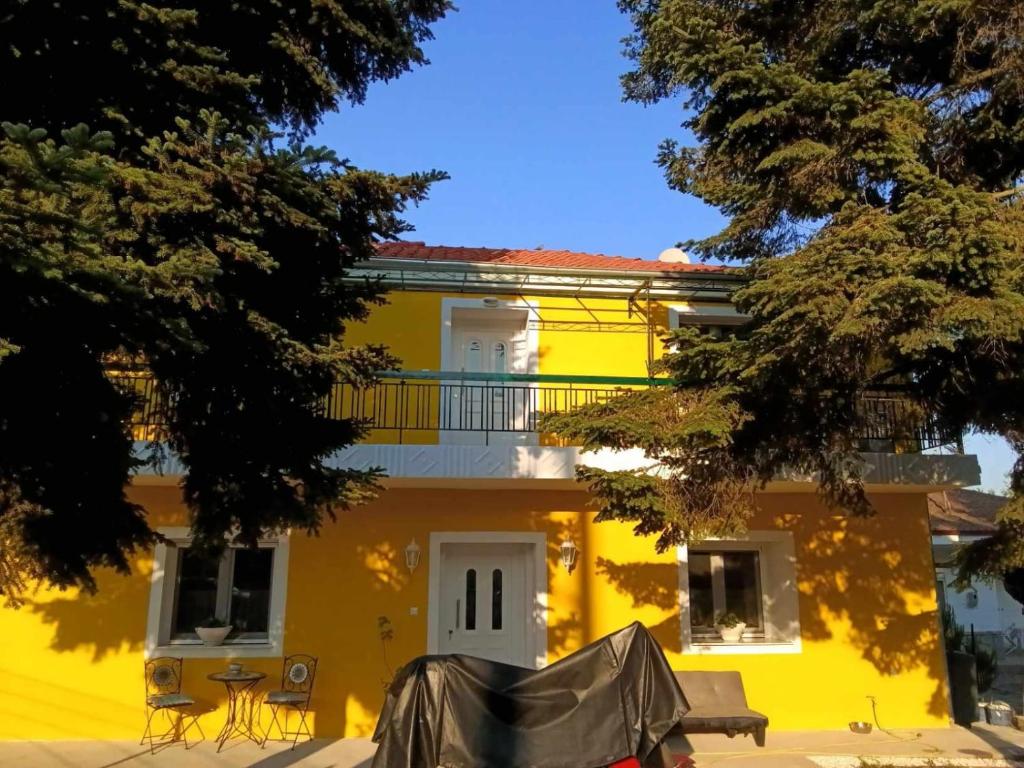una casa gialla con un balcone di fronte di Yellow House a Eleftheroúpolis