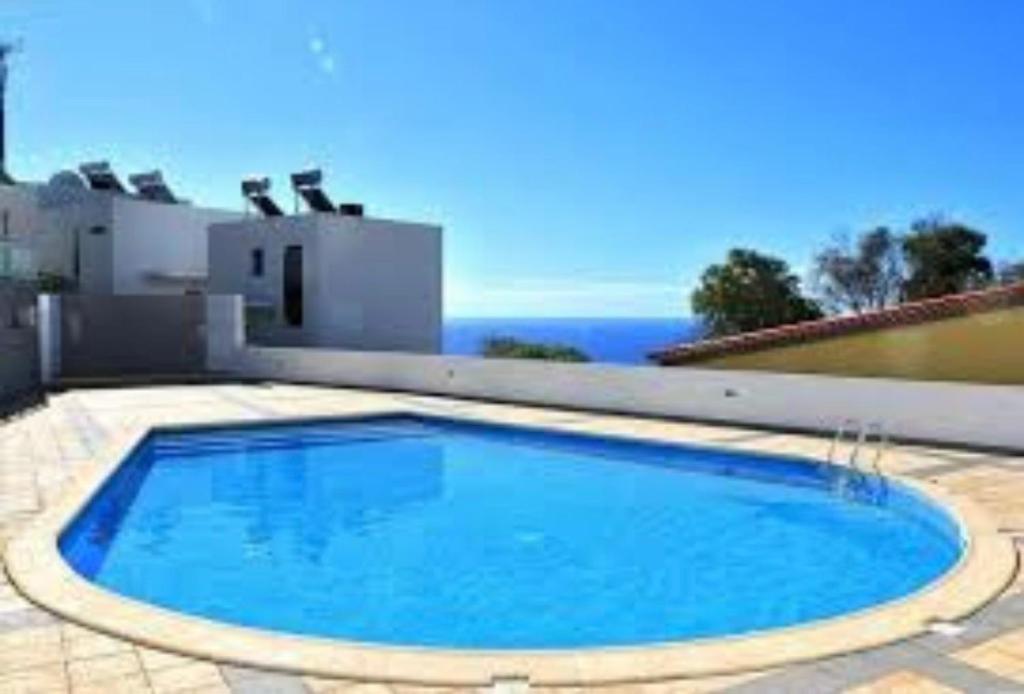 a large blue swimming pool in front of a house at Magic Paradisus guest in Caniço