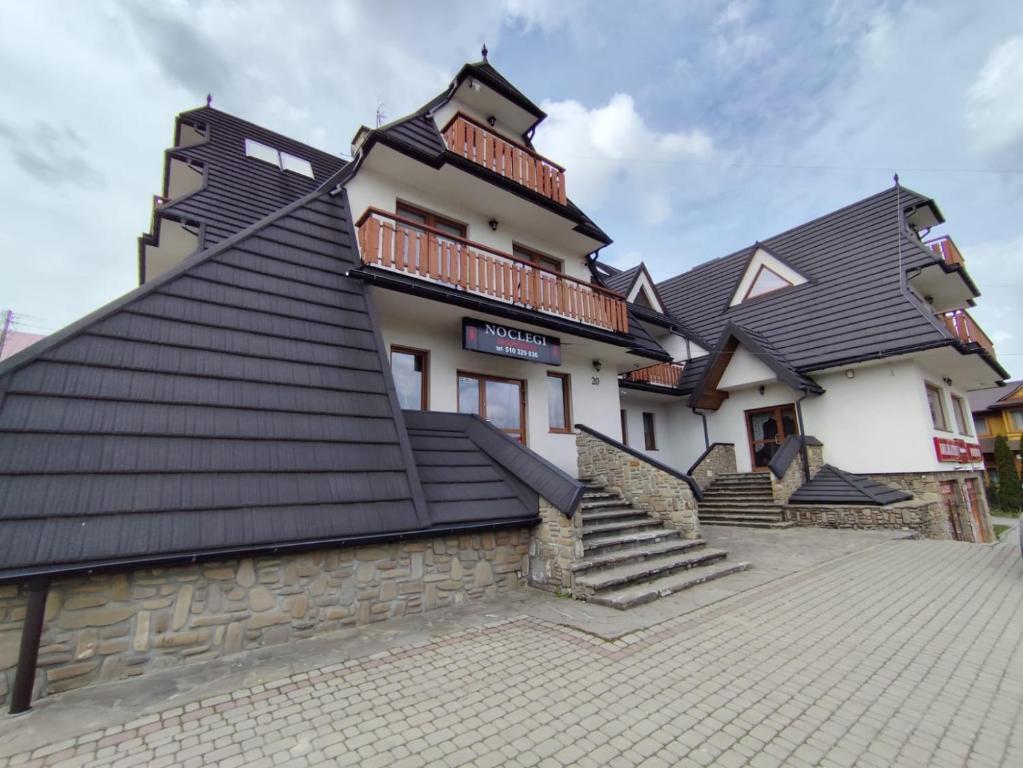 a house with a black roof and stairs at Środkowa 20 in Białka Tatrzanska