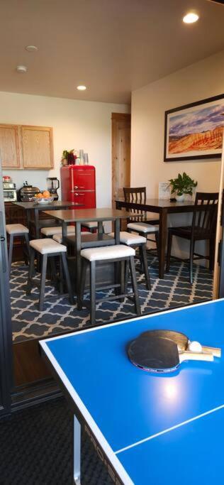 a kitchen with tables and chairs and a blue table at Beautiful Riverfront Near Mt Bachelor with Hot Tub in Bend