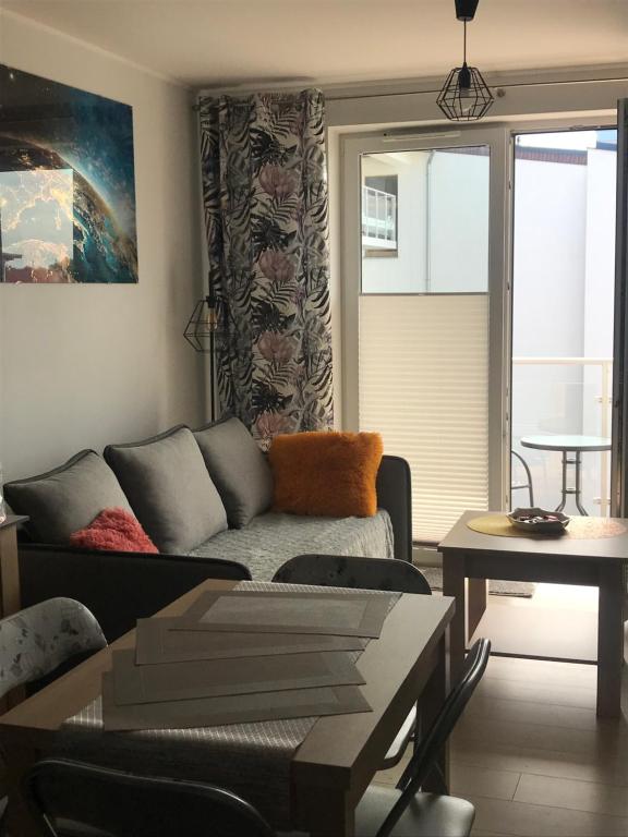 a living room with a couch and a table at Kosmos nad morzem in Dziwnówek