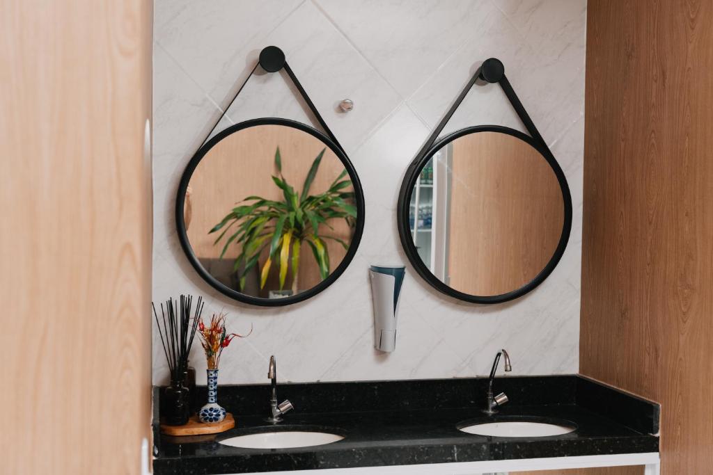 un bagno con due lavandini e due specchi sul muro di Via Brasil Hotel a São Luís