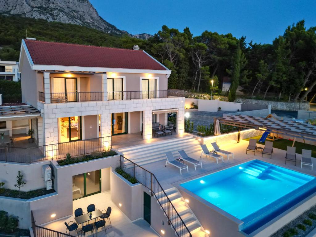 a villa with a swimming pool at night at Villa Filia in Tučepi