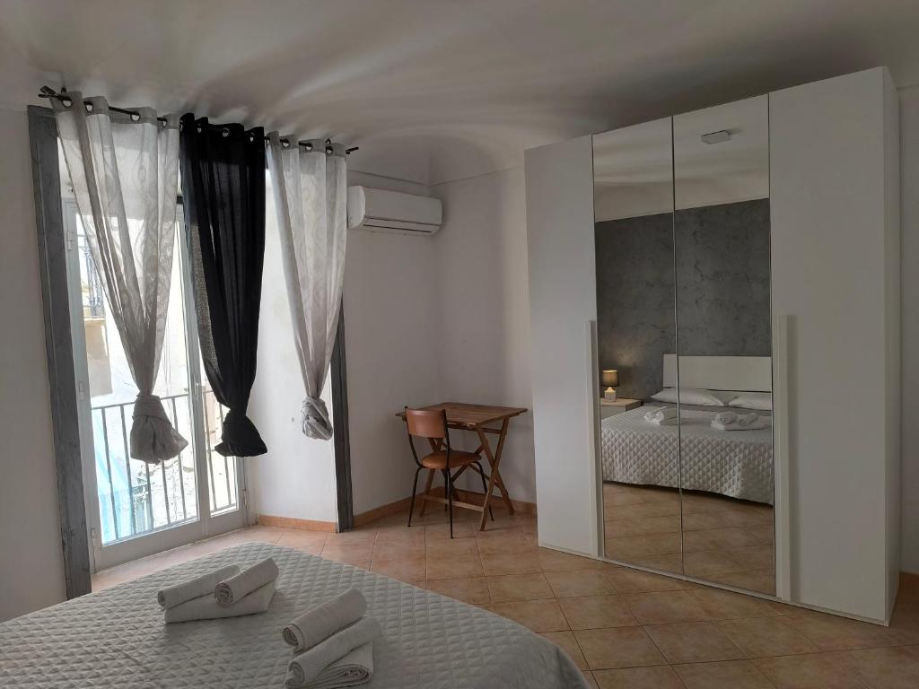 sypialnia z lustrem, łóżkiem i stołem w obiekcie Casa di Nick w Trapani