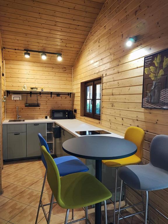 a kitchen with yellow and blue chairs and a table at SikorQa Domek nad jeziorem in Skrzeszew
