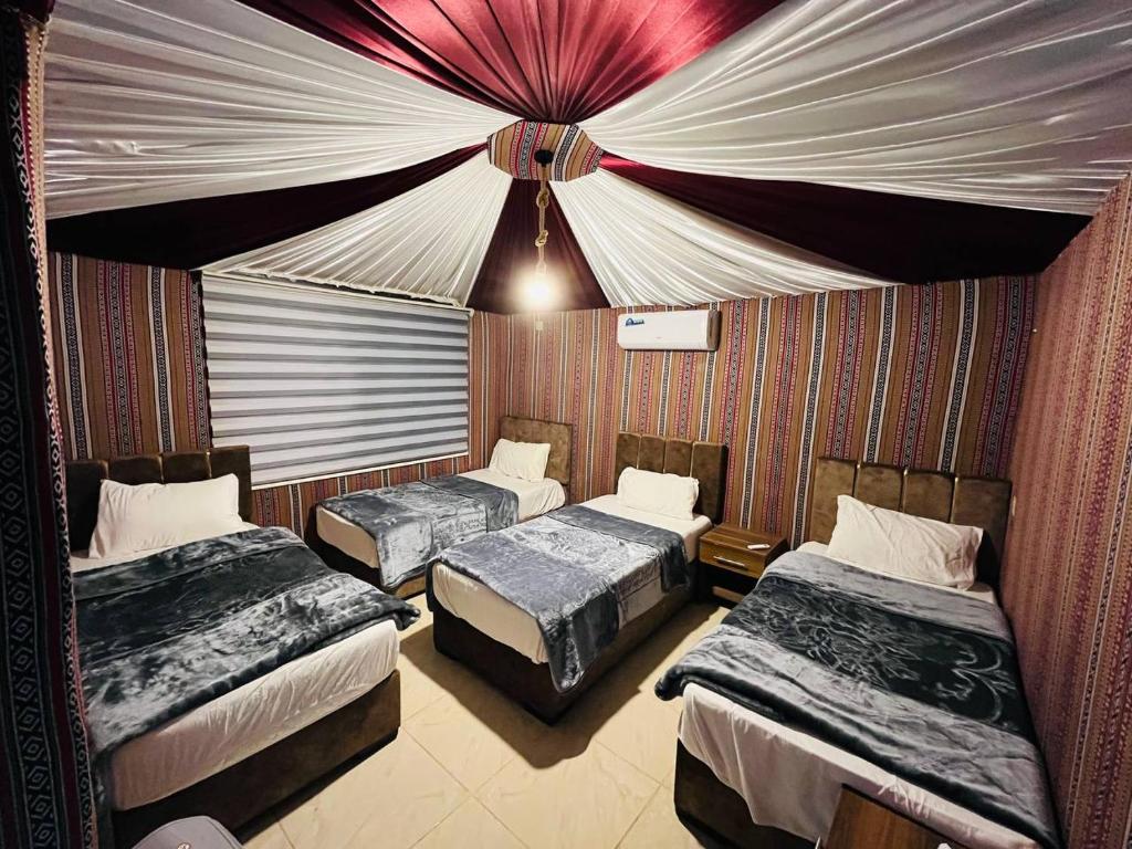 a hotel room with two beds and a ceiling at ROSELLA Wadi Rum in Disah