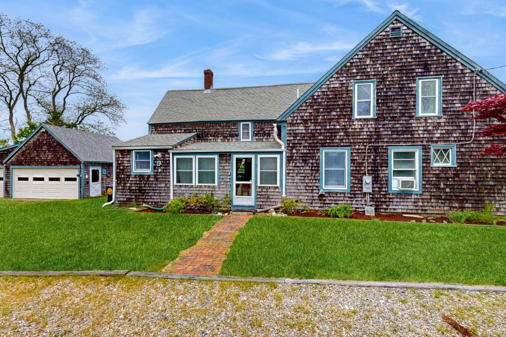 a large brick house with a grass yard at Spouter Inn in West Harwich