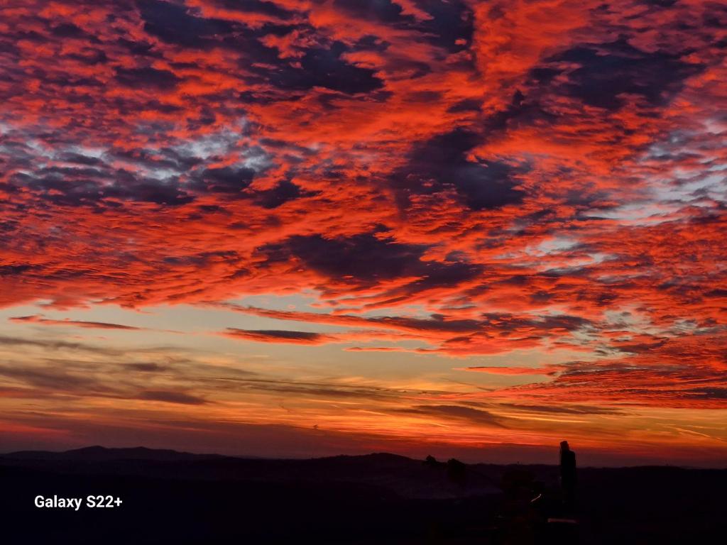 una puesta de sol con nubes rojas en el cielo en La Marginea Pădurii, en Marginea Pădurii