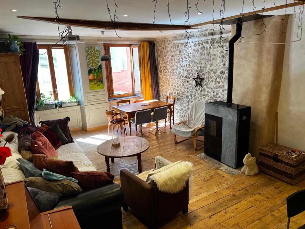 un salon avec un canapé et une cheminée dans l'établissement Appartement 110m2 chaleureux et familial, à Briançon