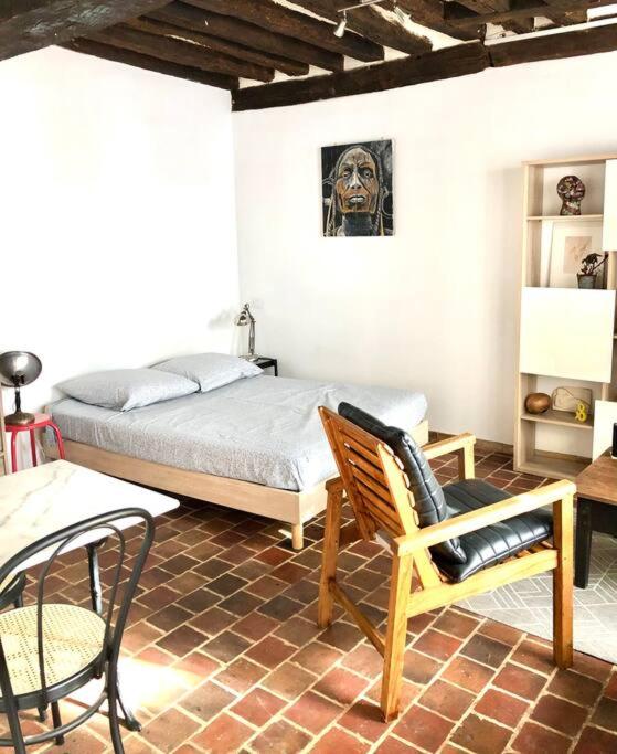 a bedroom with a bed and a chair and a table at Studio cœur de ville in Auxerre