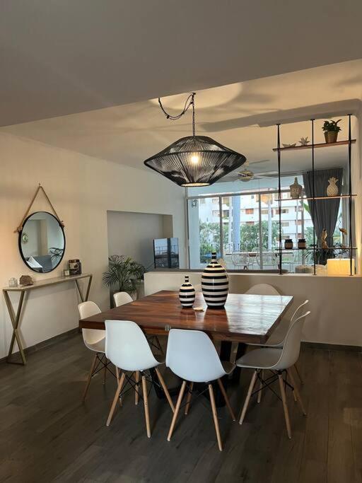 a dining room with a wooden table and white chairs at Condominio Marina Vallarta in Puerto Vallarta