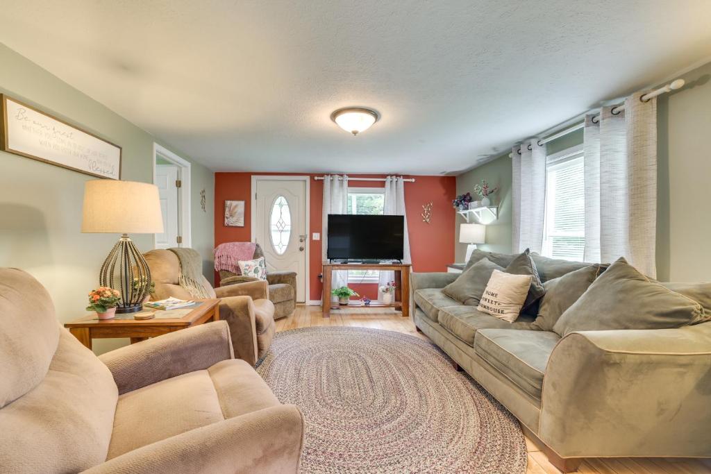 a living room with couches and a flat screen tv at Near Snowmobiling and Ice Fishing Fife Lake Retreat in Fife Lake