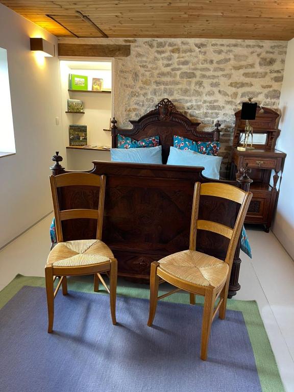 une chambre avec un lit et deux chaises dans l'établissement Les Iris, à Fontenay-près-Vézelay