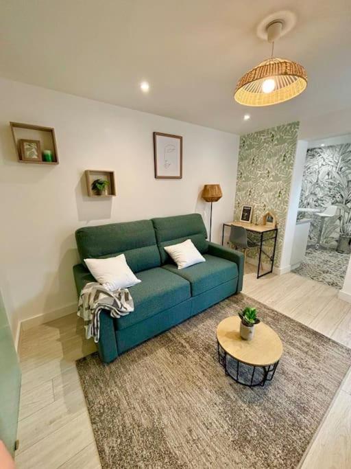 un salon avec un canapé vert et une table dans l'établissement L'Escobar Troyen, à Troyes