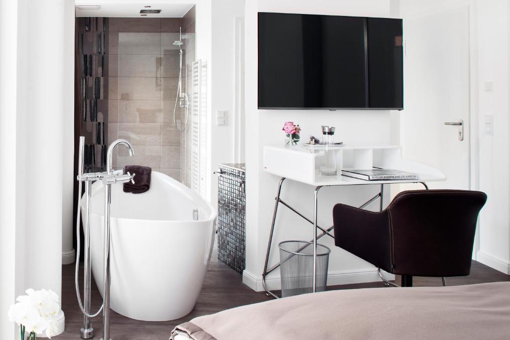 a white bathroom with a tub and a sink at Konventchen in Aschaffenburg