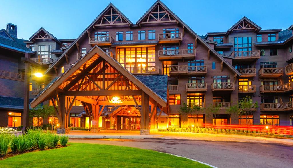 a large building with a gambrel at 1204 Lodge At Spruce Peak Ski In Ski In Ski Out King Studio By Stowe Mountain Rentals in Stowe