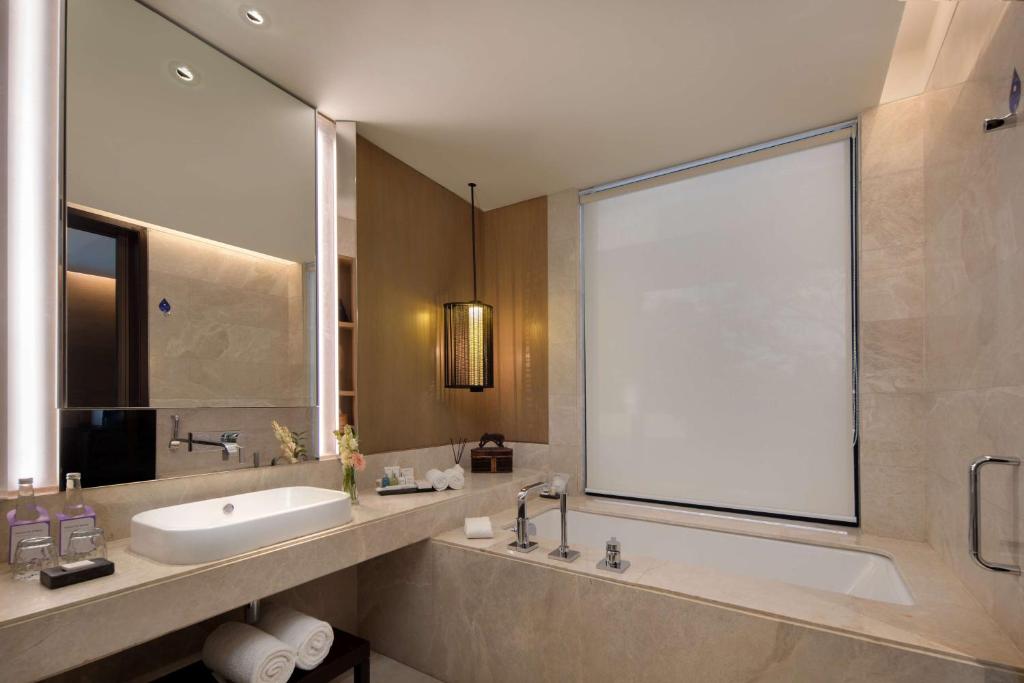 a bathroom with a sink and a large window at Radisson Blu Bali Uluwatu in Uluwatu