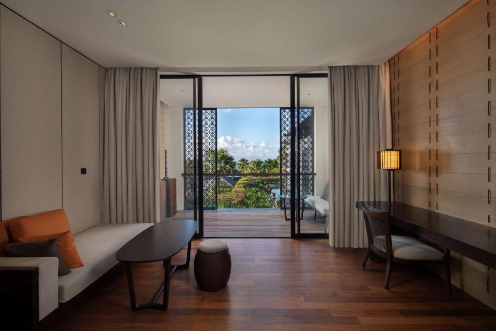 a living room with a couch and a table at Radisson Blu Bali Uluwatu in Uluwatu