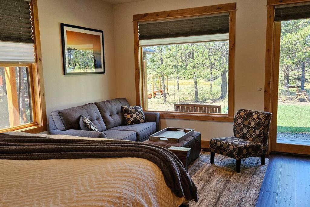 a bedroom with a bed and a couch at Beautiful Riverfront Near Mt Bachelor with Hot Tub in Bend