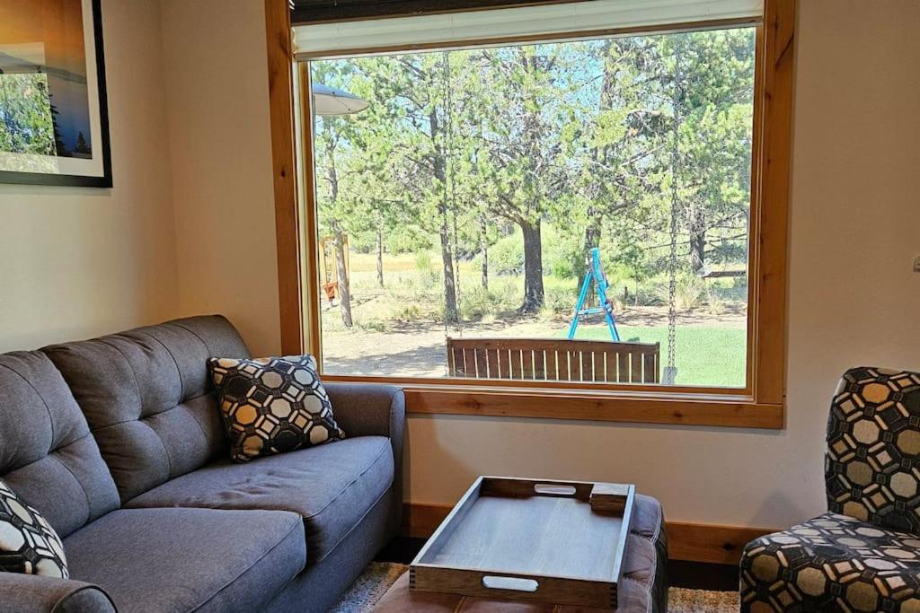 a living room with a couch and a window at Beautiful Riverfront Near Mt Bachelor with Hot Tub in Bend