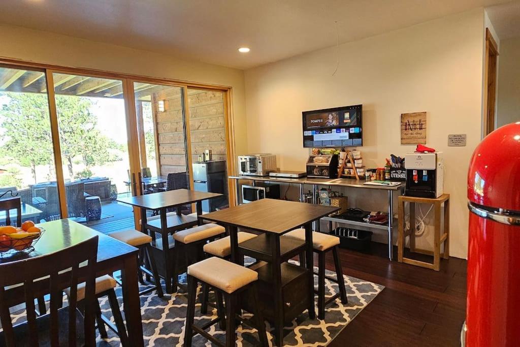 a kitchen with tables and chairs in a room at Beautiful Riverfront Near Mt Bachelor with Hot Tub in Bend